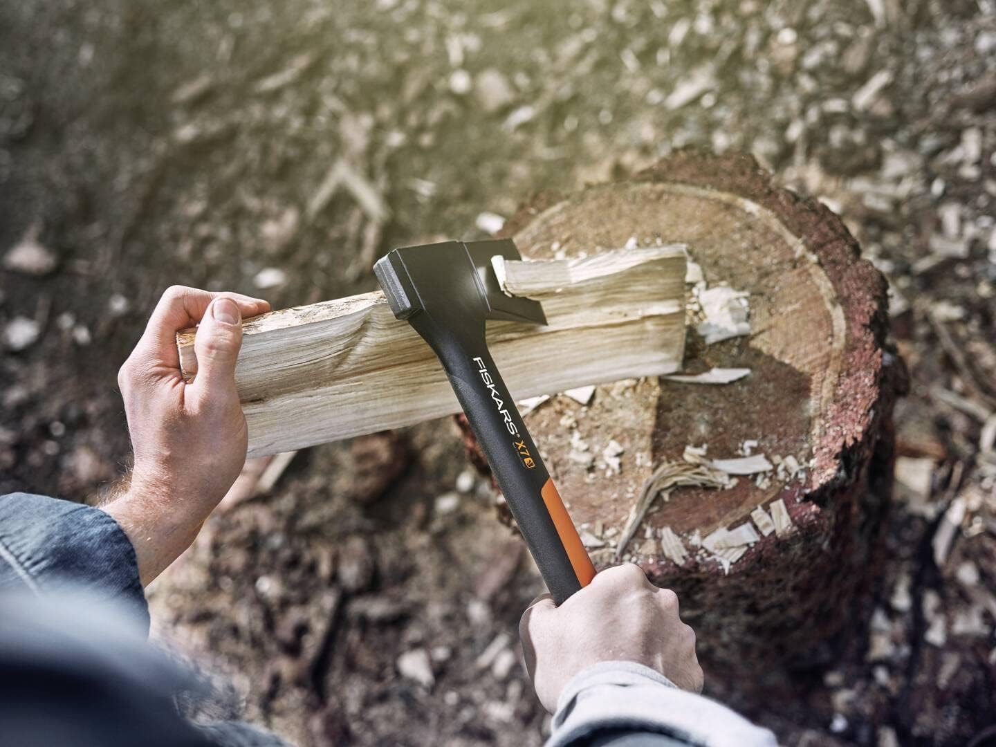 Ascia da spacco Fiskars X17 in uso per spaccare legna su un ceppo di legno, attrezzo da giardinaggio robusto e affidabile per taglio di tronchi e legna da ardere, ideale per lavori di falegnameria e campeggio, impugnatura ergonomica e resistente.