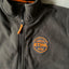 Giacca in pile nera STIHL con zip, dotata di logo arancione "Legendary Performance STIHL Since 1926" sul petto. Ideale per lavoro all'aperto e tempo libero, offre comfort e calore. Abbigliamento ufficiale STIHL di alta qualità.