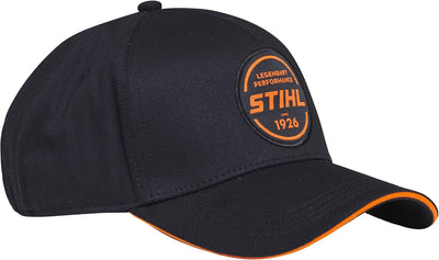 Cappellino da baseball nero STIHL con logo arancione "Legendary Performance Since 1926", visiera curva e bordi arancioni, ideale per protezione solare e stile casual, accessorio perfetto per appassionati di attrezzature STIHL e attività all'aperto.