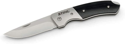 Coltello pieghevole STIHL con lama in acciaio inossidabile, manico ergonomico nero e argento. Utensile multiuso ideale per campeggio, escursionismo e attività all'aperto. Design compatto e resistente, perfetto per ogni avventura.