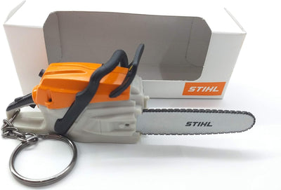 Portachiavi a forma di motosega Stihl con confezione originale. Design realistico con dettagli arancioni e neri. Perfetto per appassionati di bricolage e giardinaggio. Idea regalo unica e pratica per tenere le chiavi organizzate.