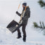 Uomo con giacca invernale e berretto usa una pala da neve ergonomica su un paesaggio innevato, attrezzatura ideale per rimuovere la neve in inverno, robusta e facile da maneggiare.