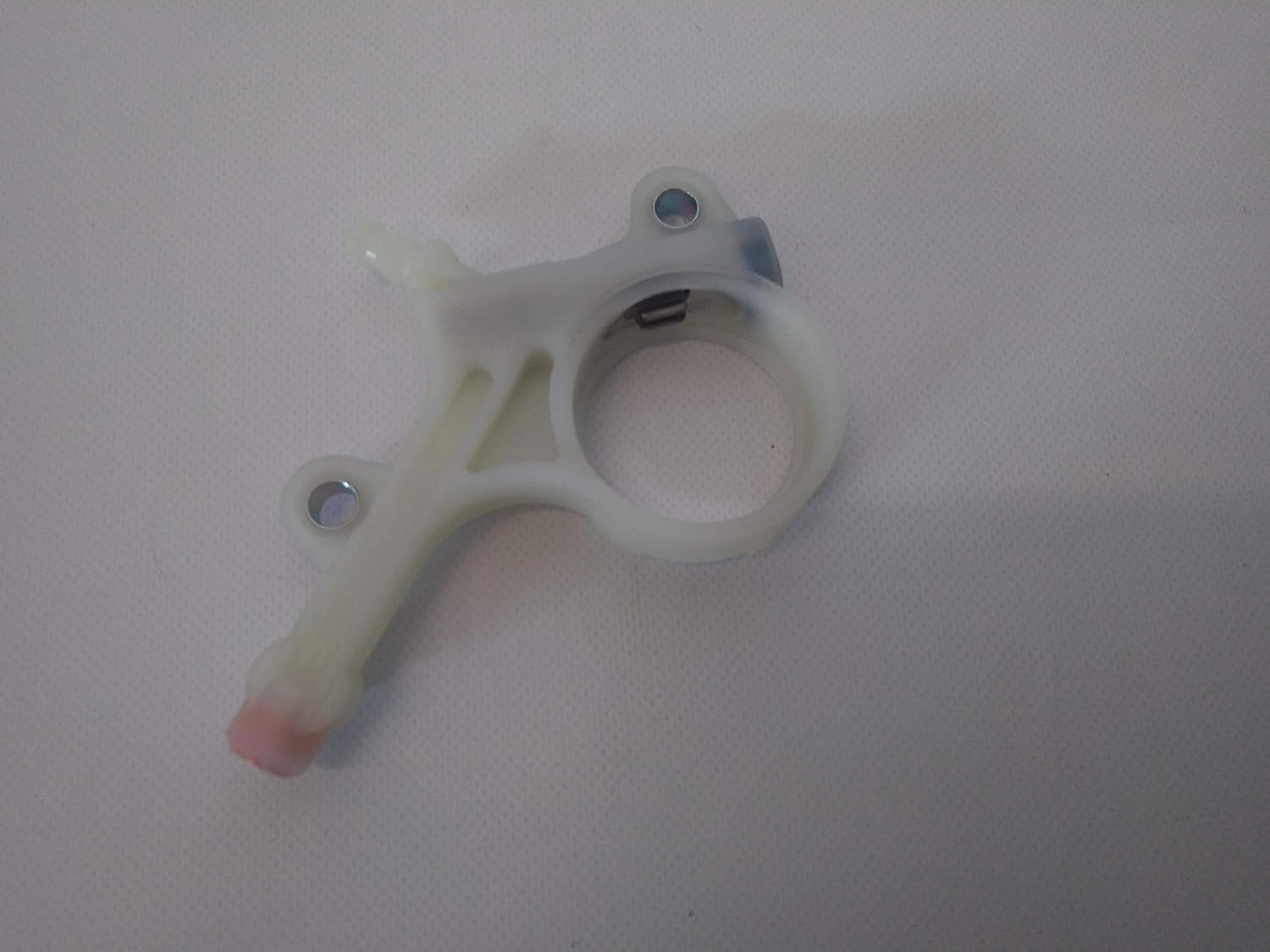 Supporto in plastica bianca per componenti meccanici, con due fori per viti di fissaggio e un anello centrale, ideale per applicazioni industriali. Accessorio di ricambio per macchinari, resistente e di alta qualità.